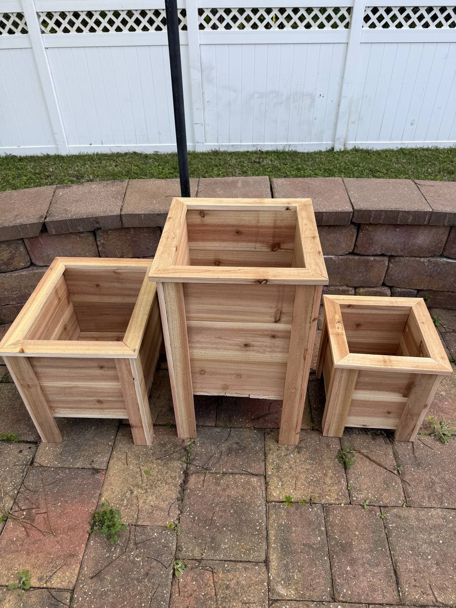 Cedar trio planter set — three graduated square planter boxes displayed together on a brick patio