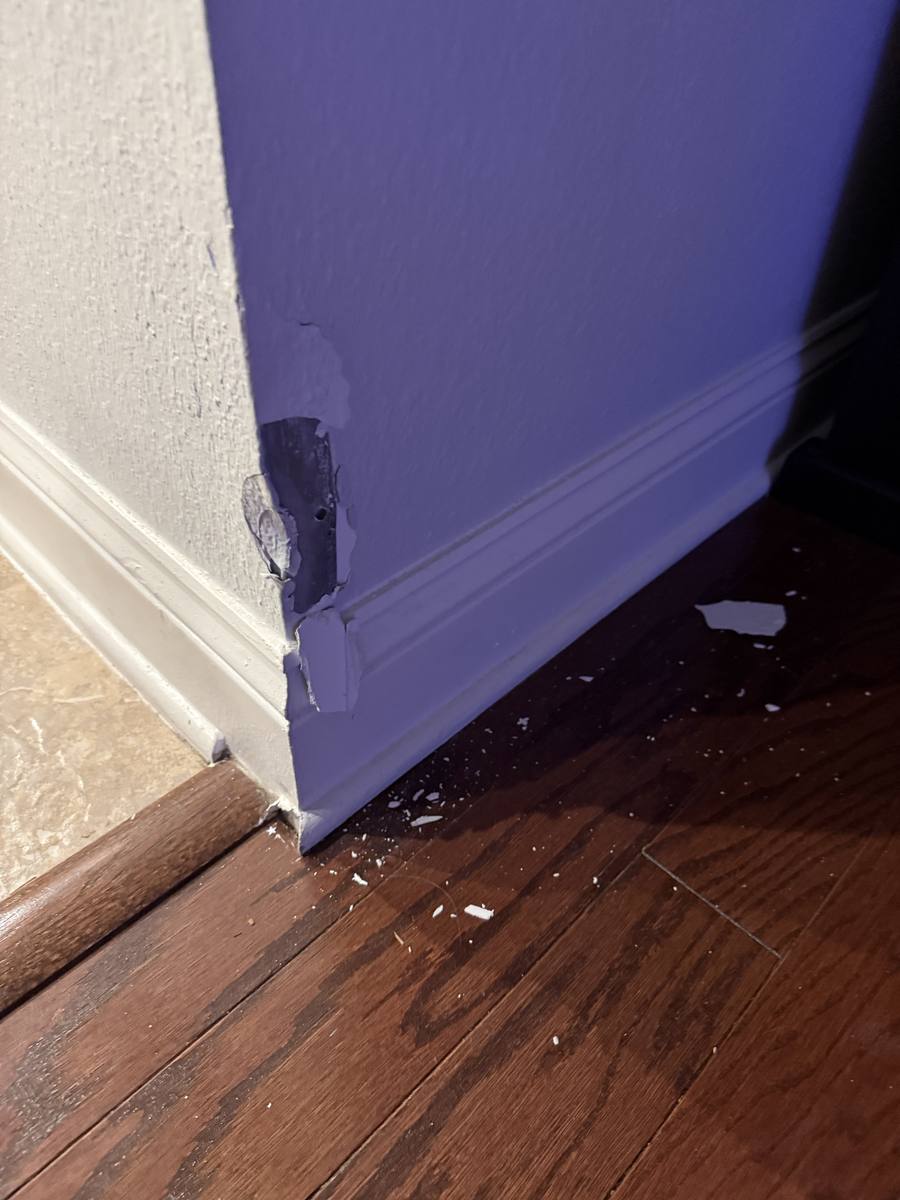 Corner bead damage — chipped paint and peeling drywall