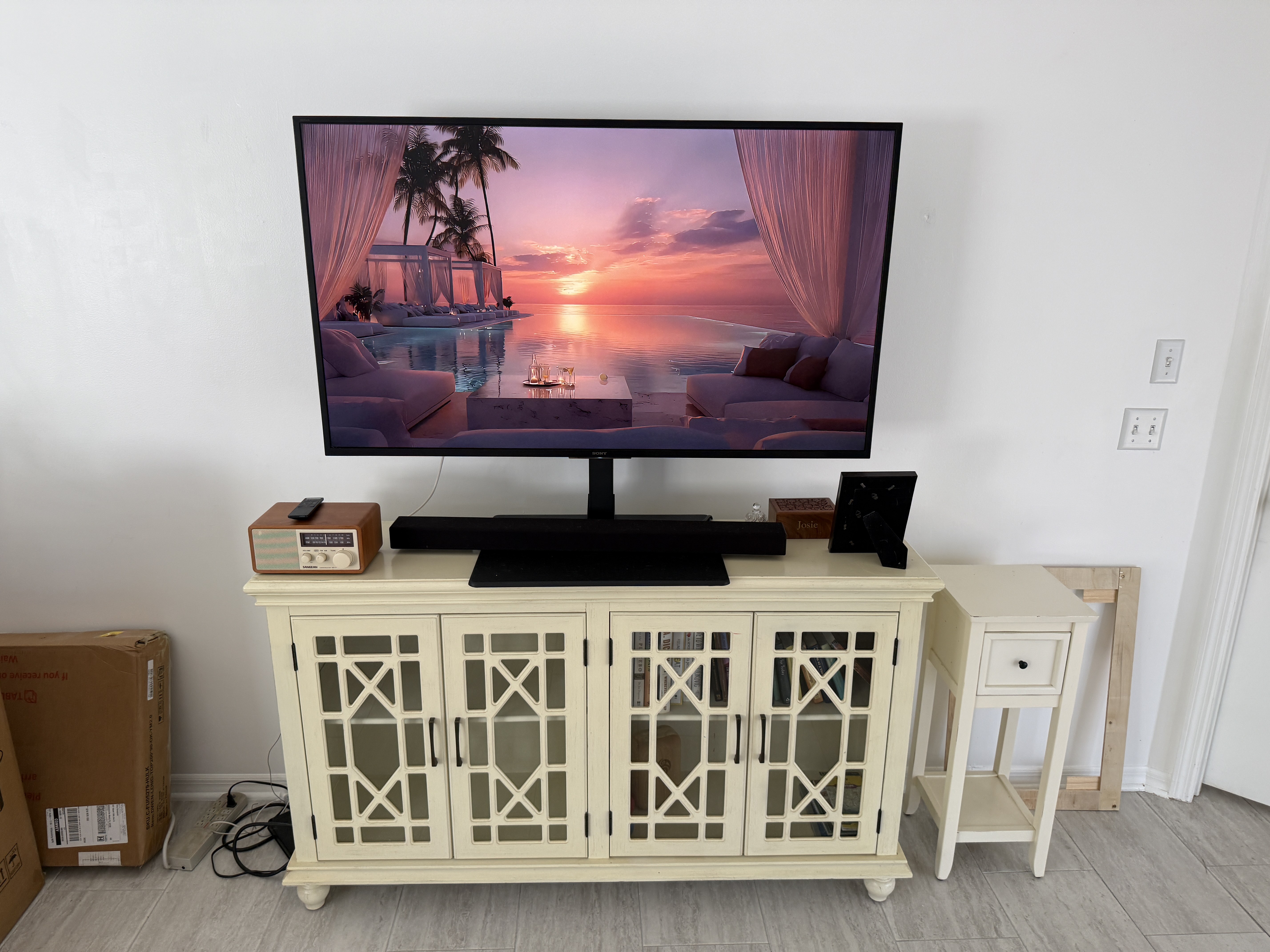 TV sitting on entertainment console before wall mount