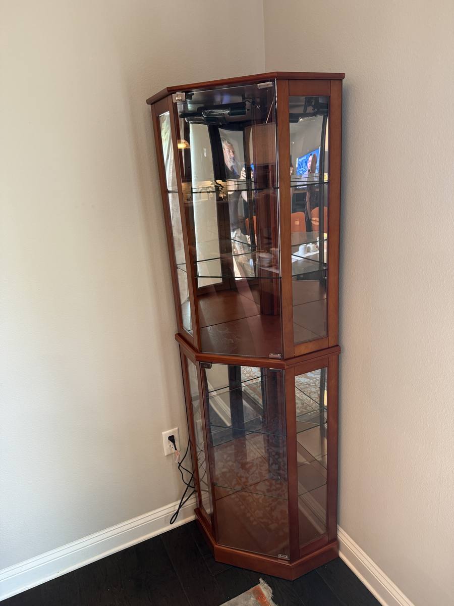 Assembled two-piece corner curio cabinet with glass shelves and mirrored back — fully assembled in corner