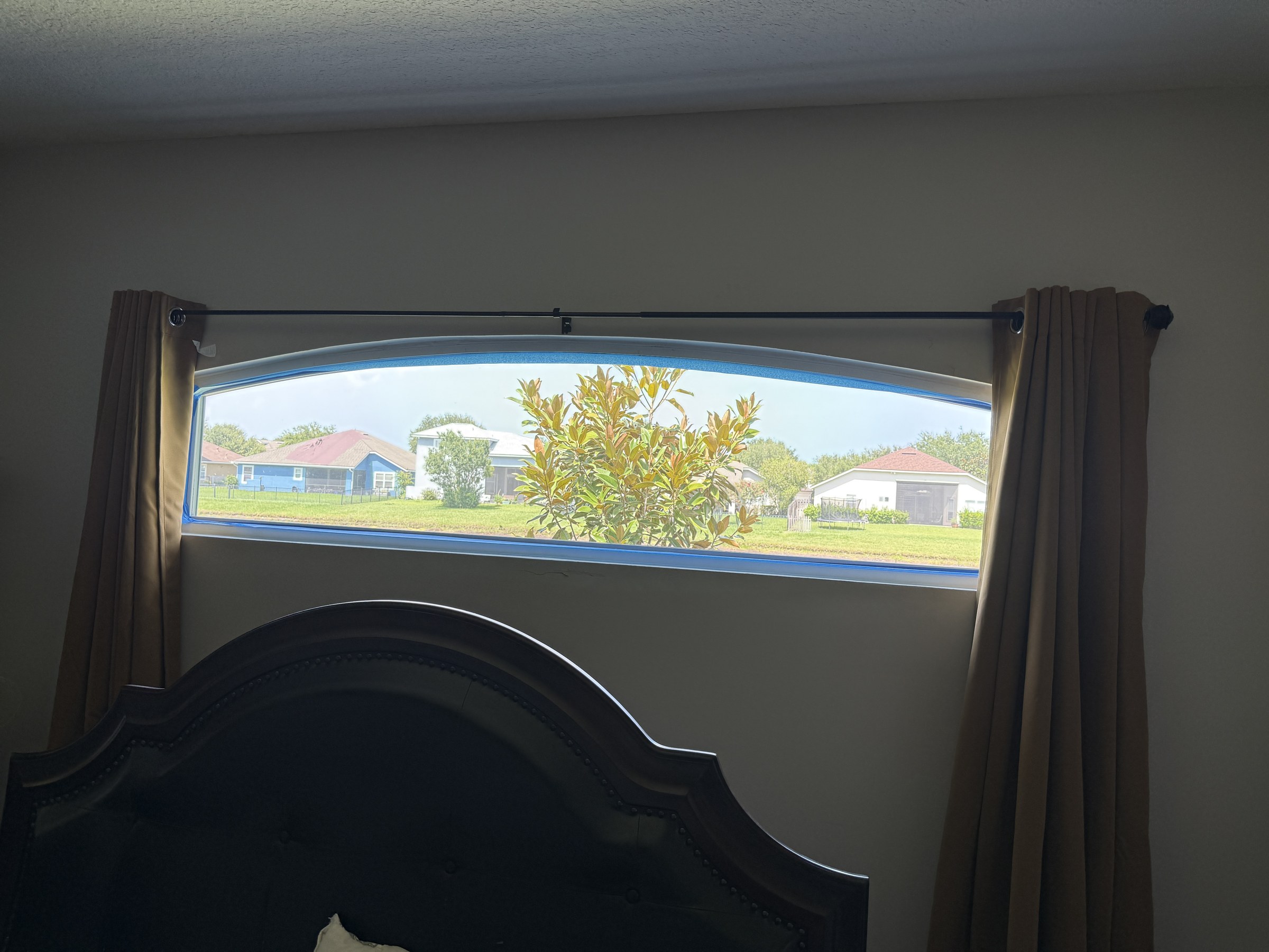 Arched bedroom window with clear glass — no privacy
