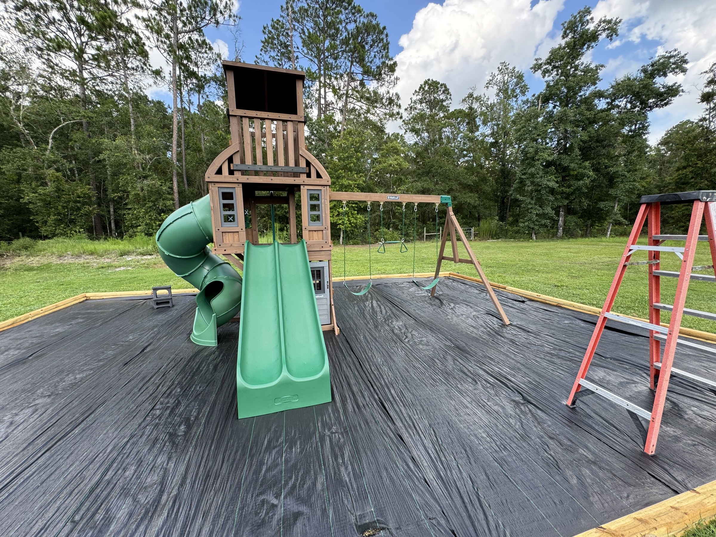 Completed playset with tube slide and swings fully installed