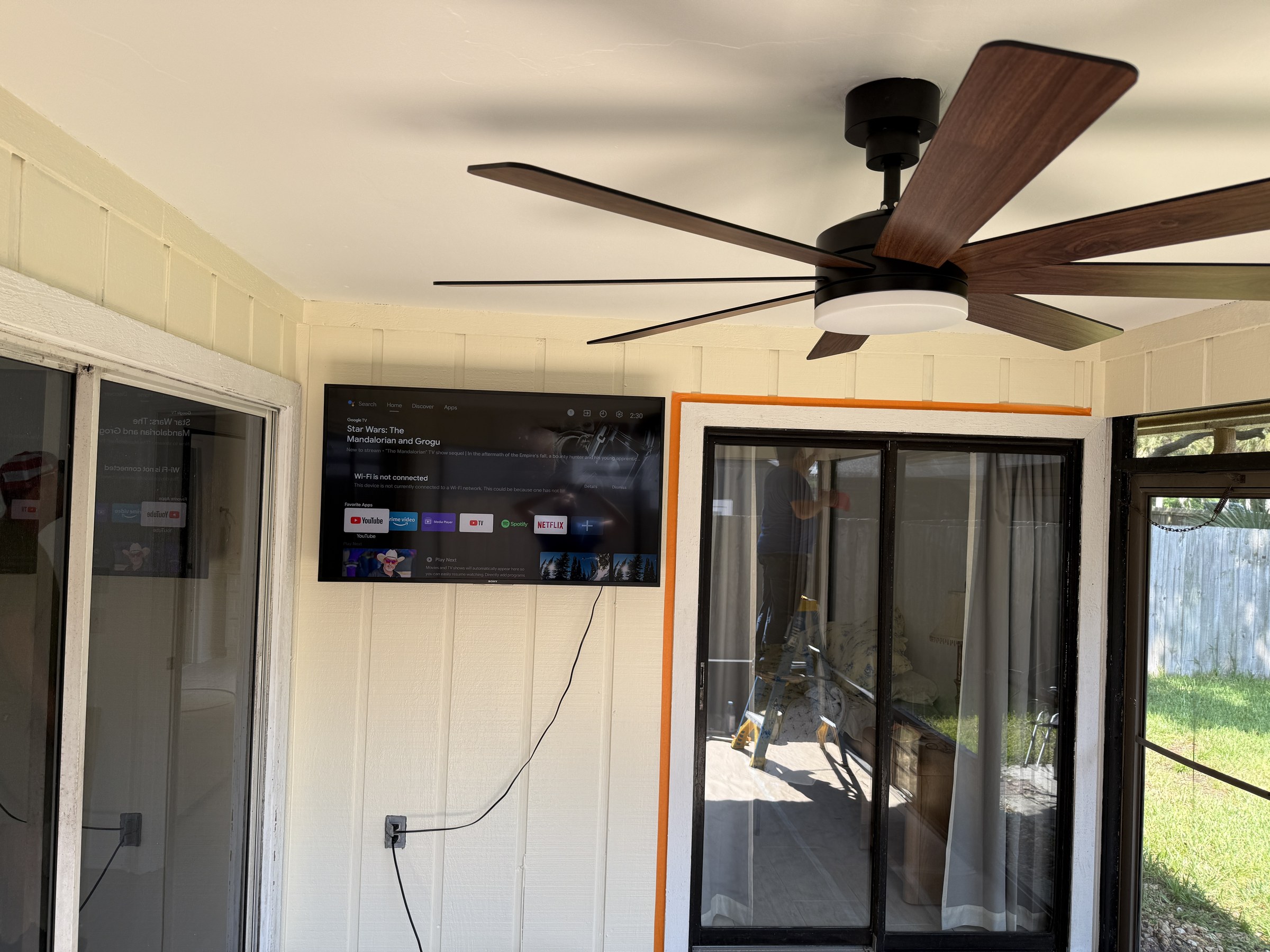 Enclosed porch after — outdoor TV wall-mounted, new fan, roof recoated