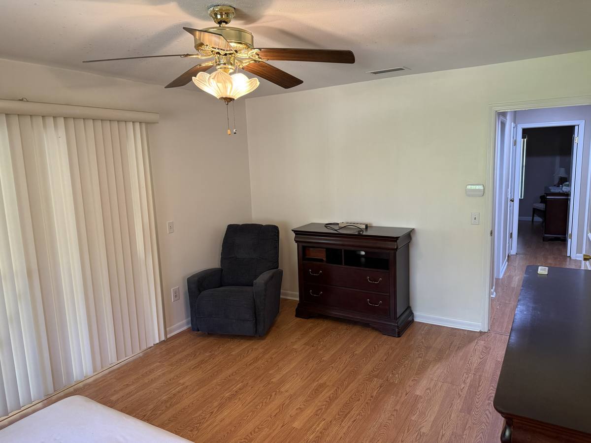 Second bedroom finished with new hardwood floors, assembled furniture and recliner in place