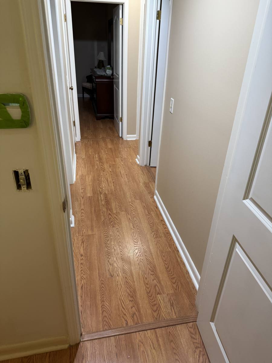 Hallway second angle after paint and trim repair — refreshed walls, white trim, and painted doors throughout