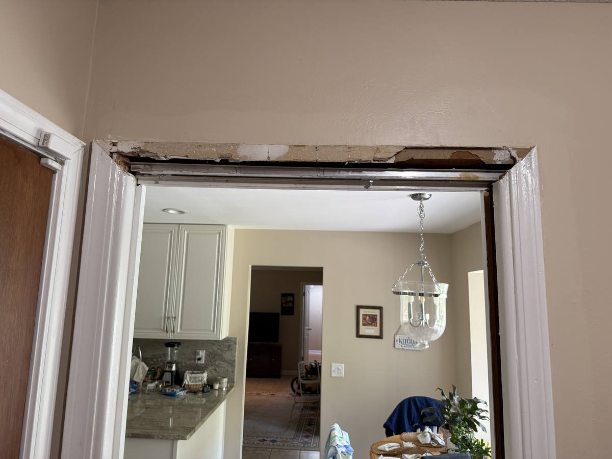 Damaged pocket door frame removed — peeling header and trim before repair