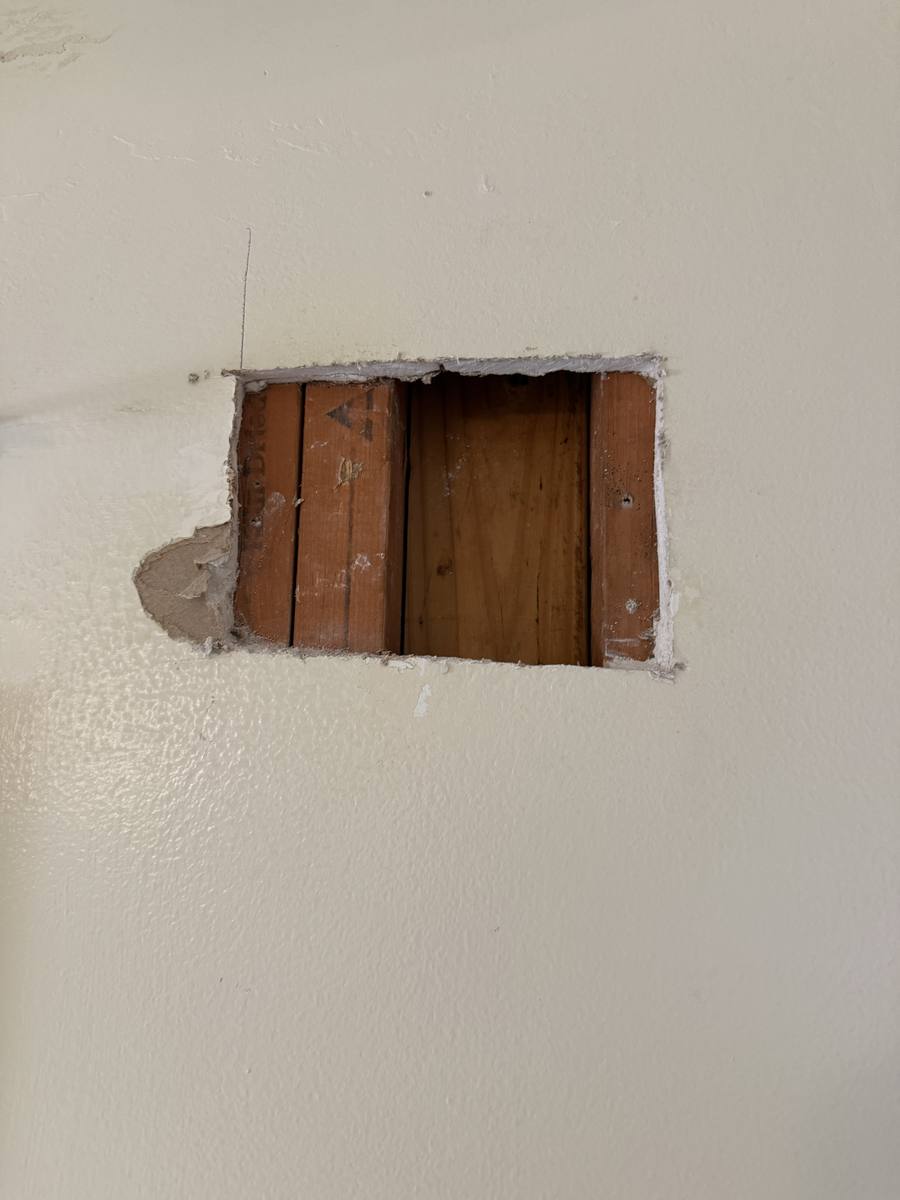 Wall damage repair in progress — drywall patching and framing work underway