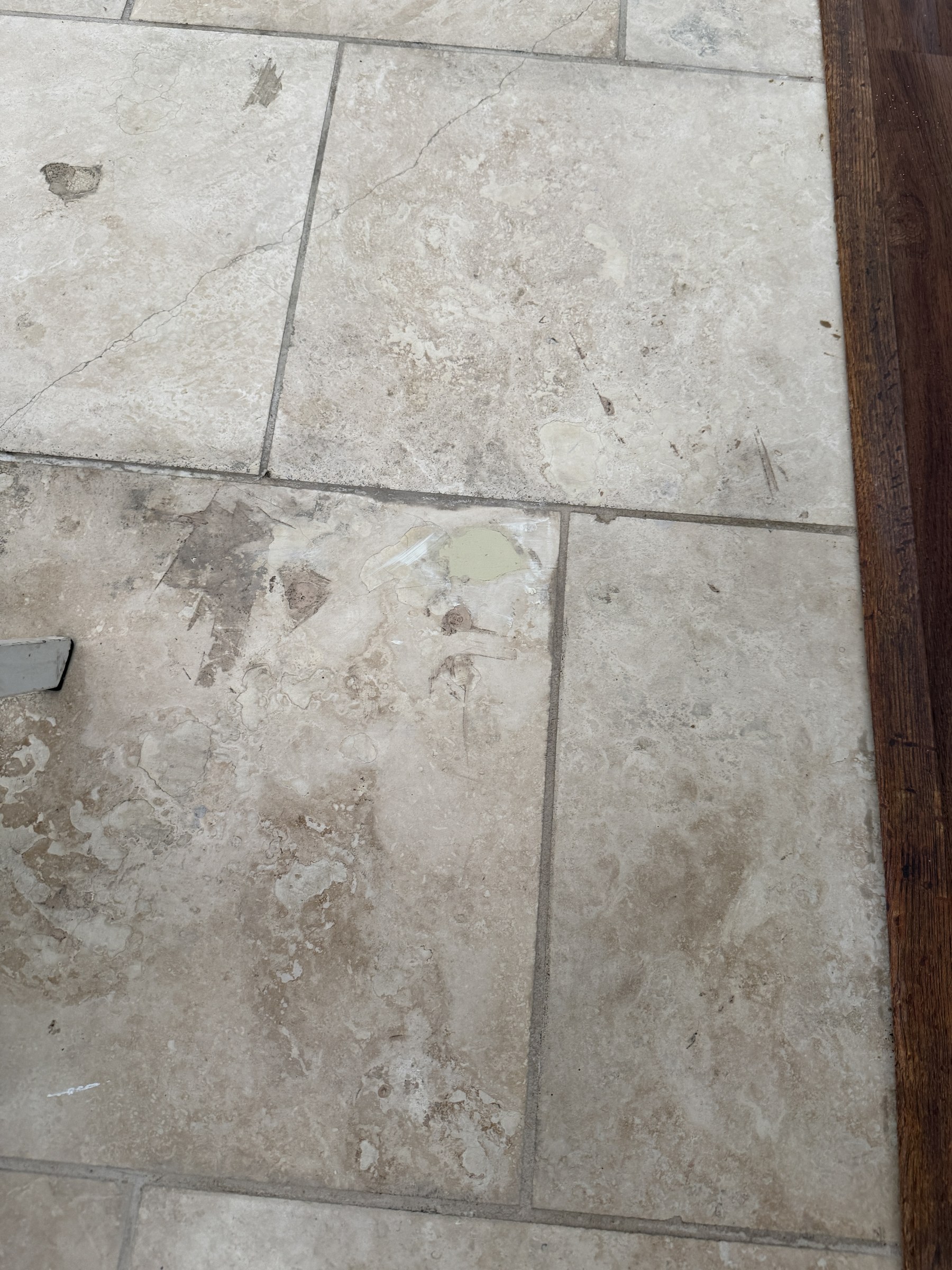 Travertine tile repaired — surface restored to match surrounding floor