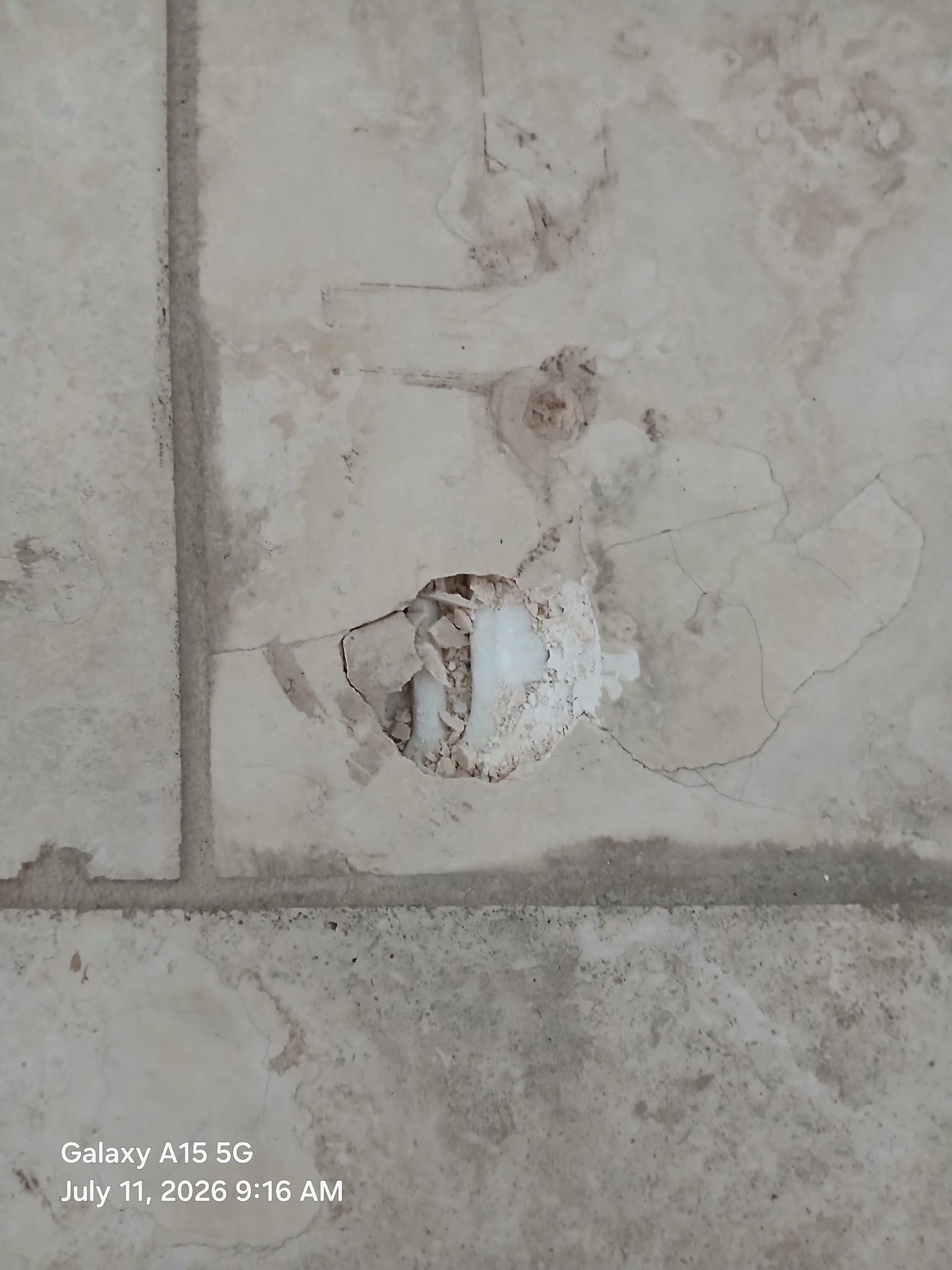 Travertine floor tile with large hole punched through